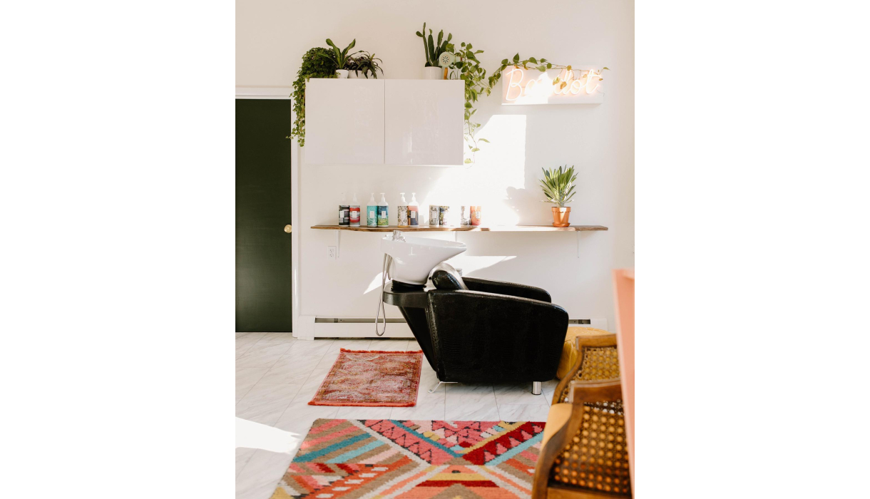 Shampoo station with potted plants and decorative rugs for a pop of color