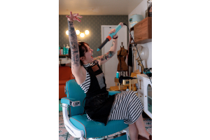Stylist striking a fun pose with a curling wand at Curl Up and Dye Salon in Flagstaff, AZ