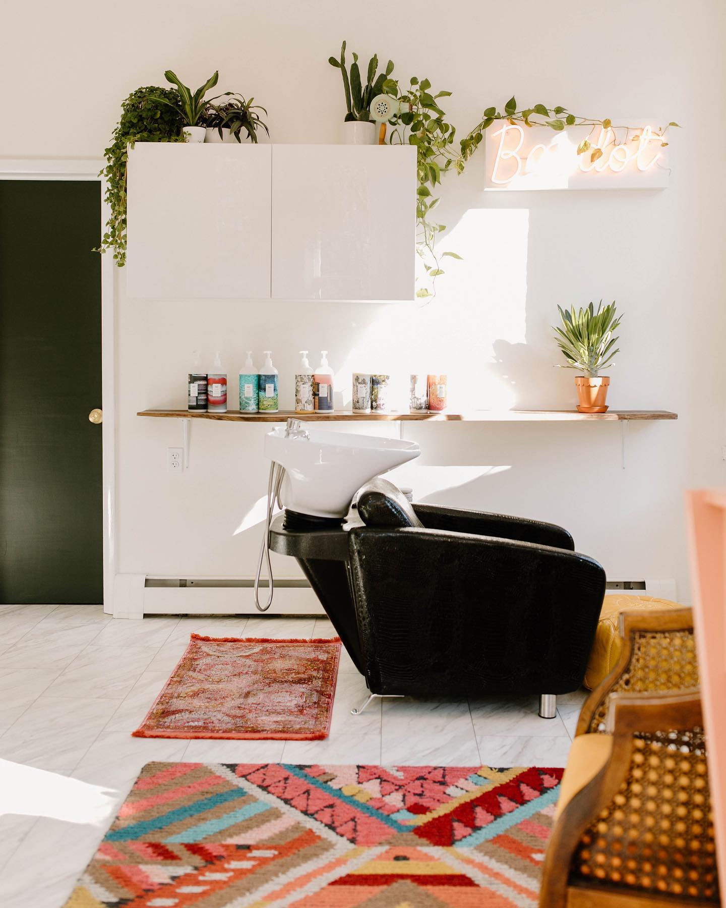 Shampoo station with potted plants and decorative rugs for a pop of color