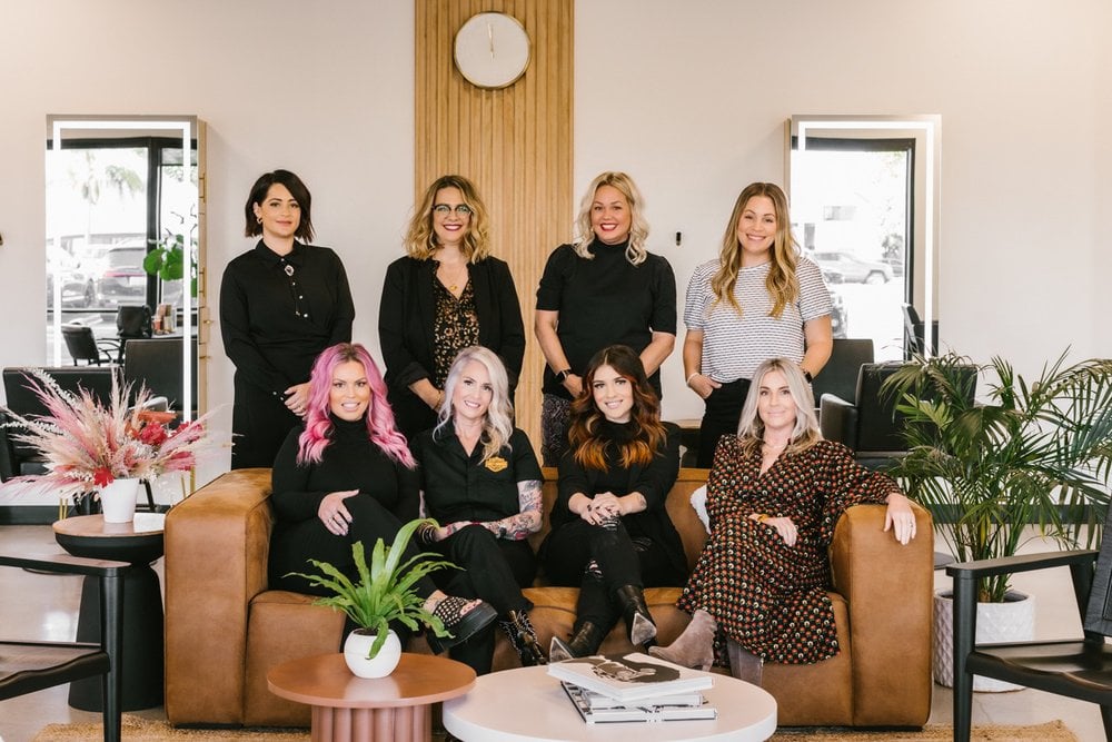 eight salon stylists posing together